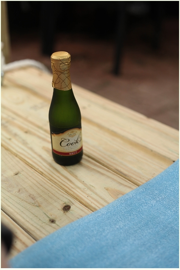 miniature bottle of champagne on a wooden platform
