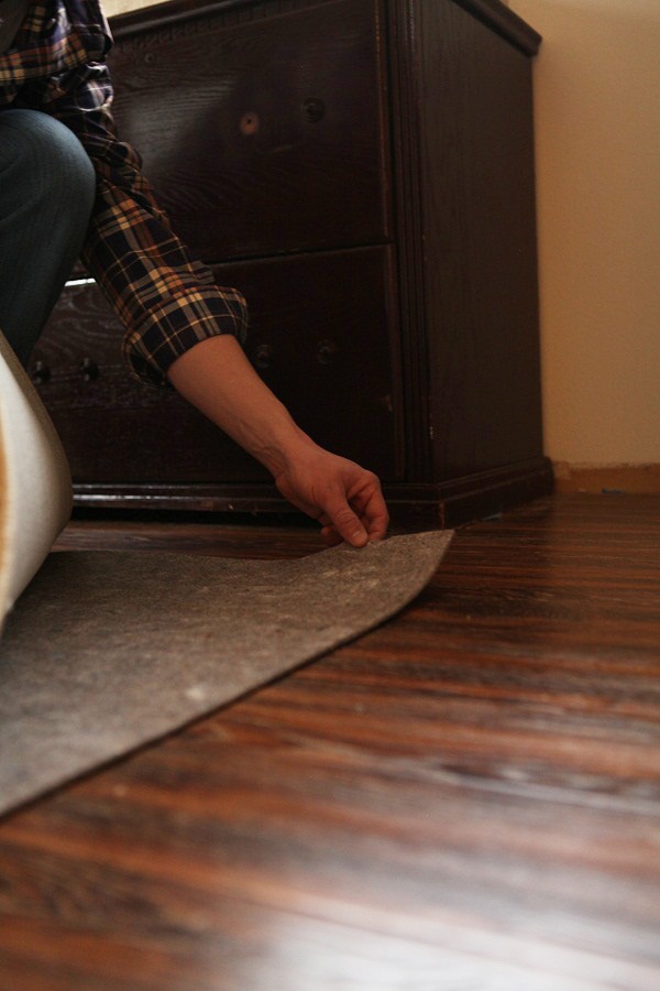 A thick rug pad beneath a large rug.