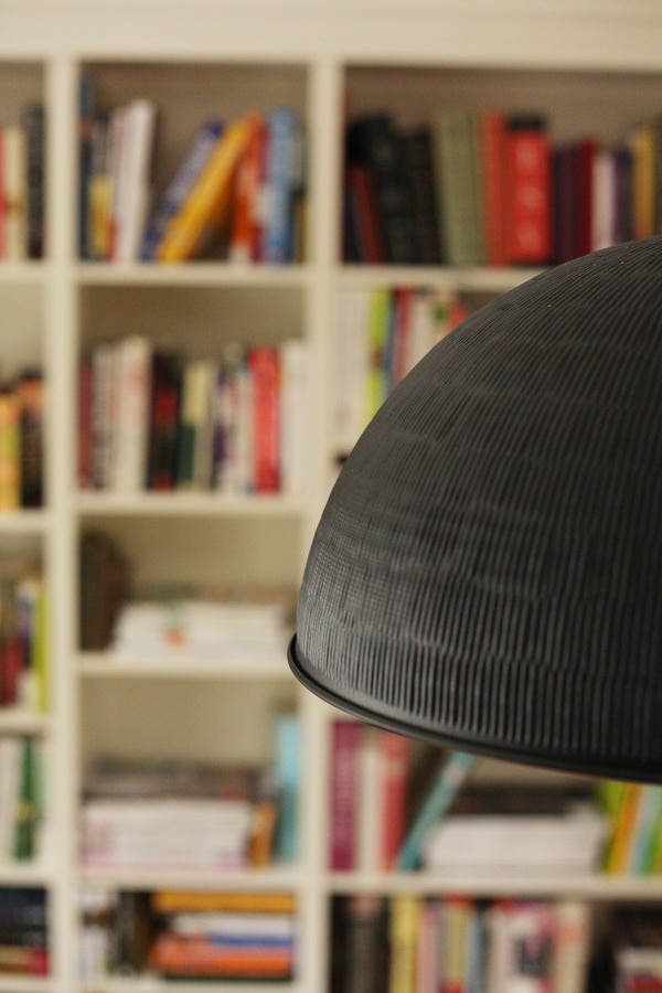 A close up of pendant light with bookshelves in the background.