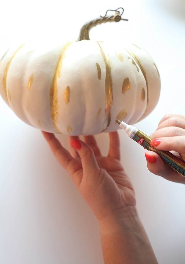Use a liquid gold leaf pen to draw polka dots on a pumpkin.