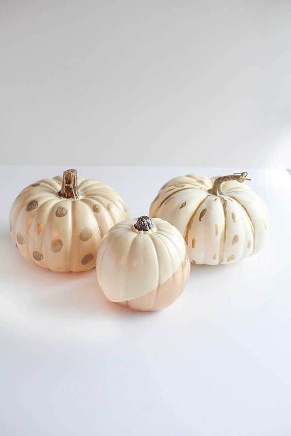 White and gold pumpkins on a white surface. 