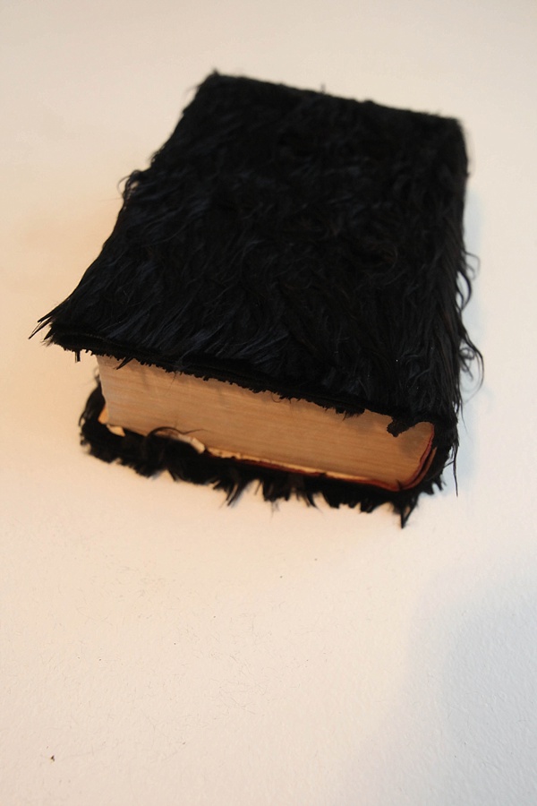 An old book with black faux fur on the cover