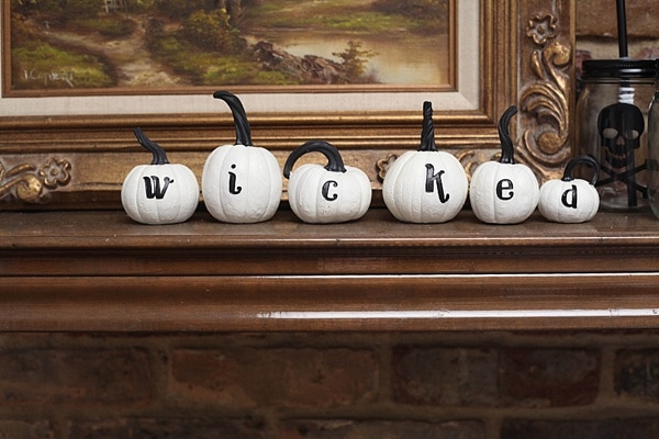 white pumpkins with letters painted on them