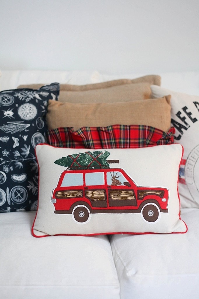 I love this throw pillow of a car with a tree on top driven by a reindeer