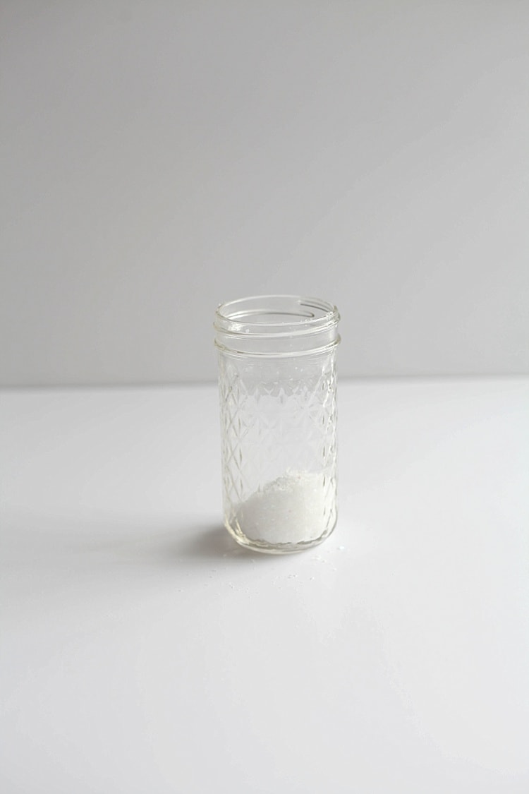 Faux snow in a mason jar on a white surface