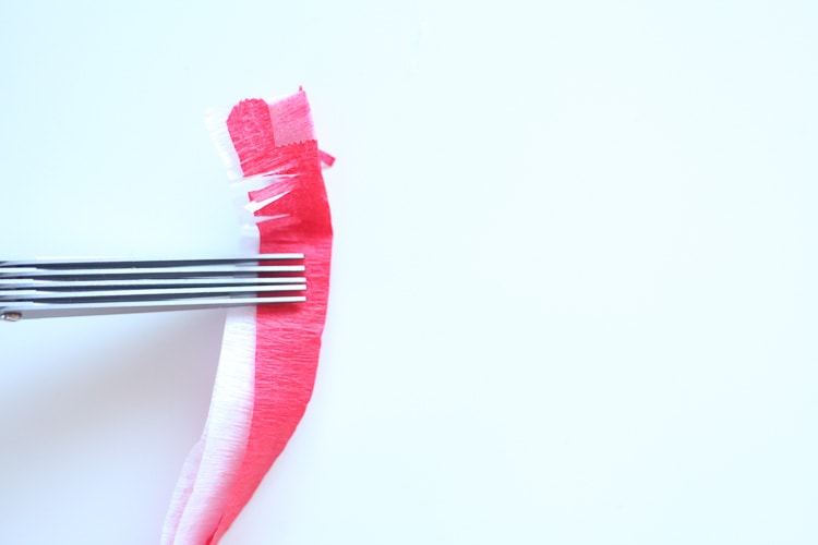 Using fringe scissors to cut fringes in the crepe paper streamers