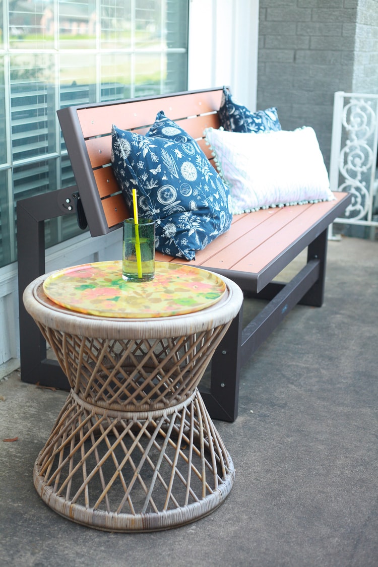 front porch with bench, decorative pillows, and a table with a drink