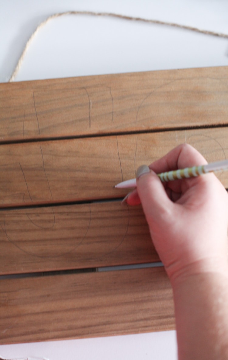 free-handing letters on wood plank sign