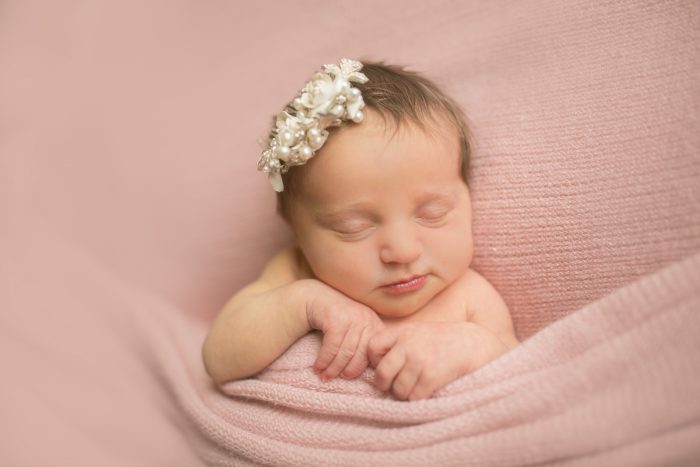 Such a sweet photo idea—this baby girl is wearing mom's wedding comb in her newborn pictures! 