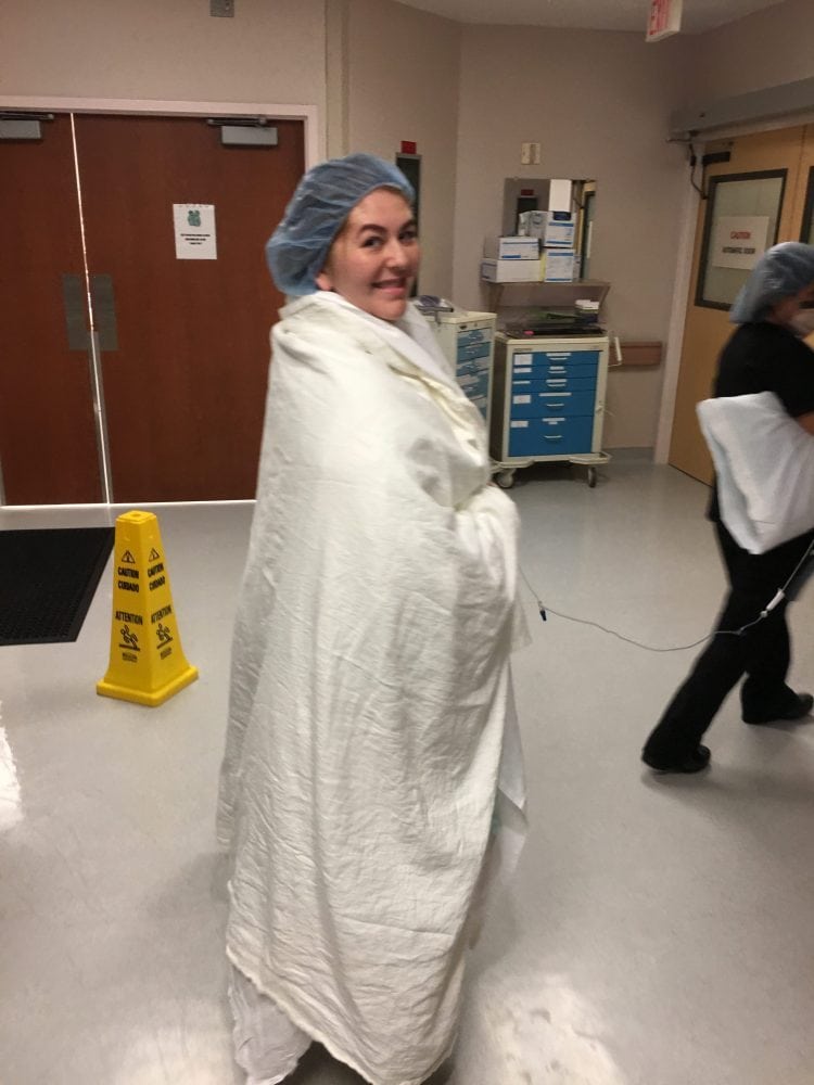 Woman wrapped in blanket walking into delivery room before c-section