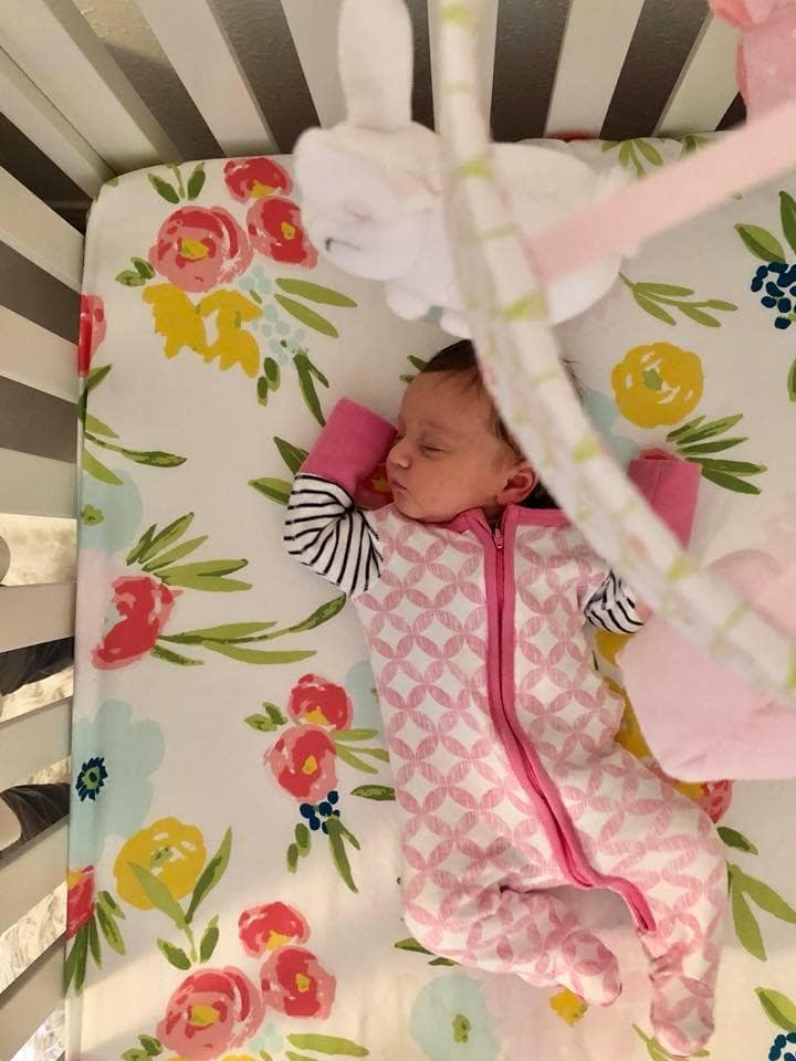 newborn girl asleep in crib
