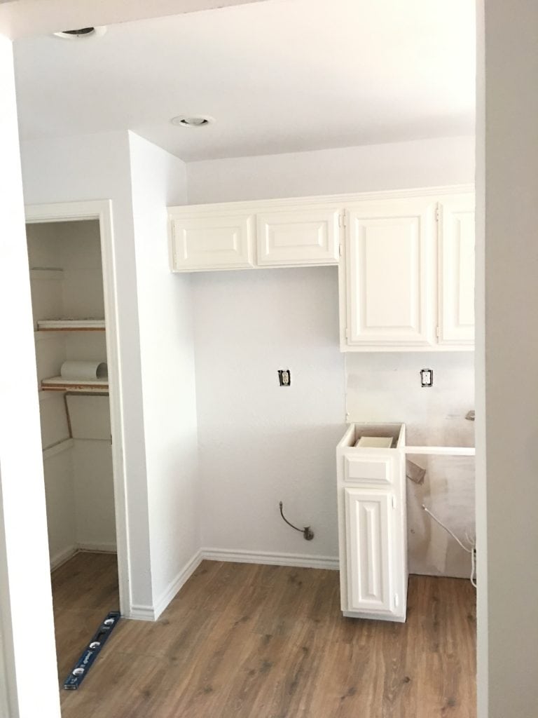 white painted kitchen cabinets with spot for fridge