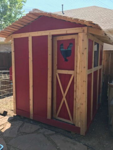 red chicken coop with tin roof