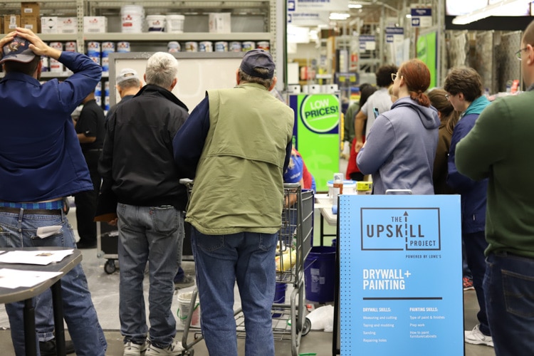 crowd of people watching a drywall demonstration at Lowe's