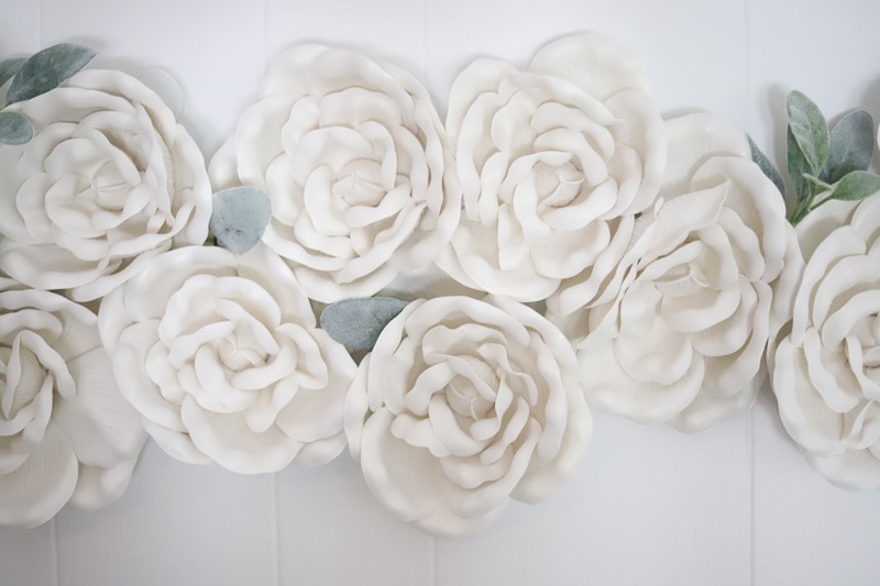White foam flowers with leaves hung as living room decorating idea