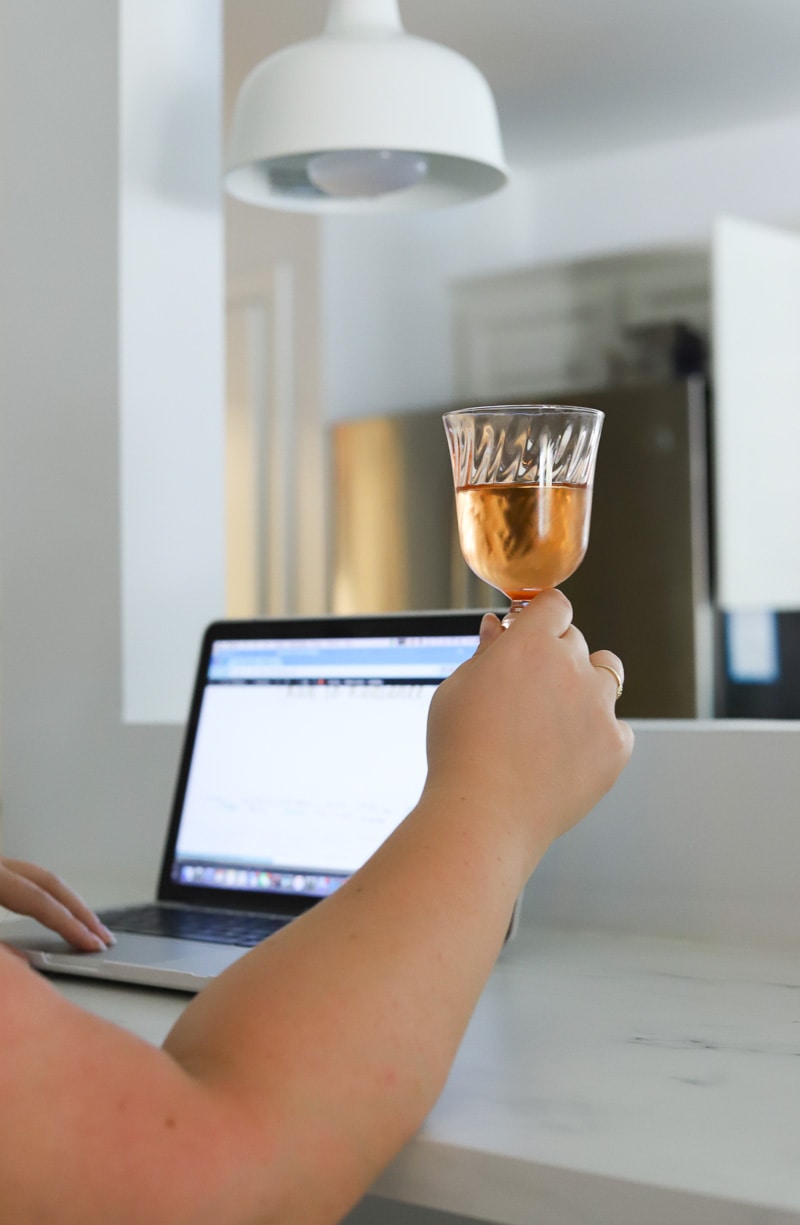 Woman drinking rose wine while working