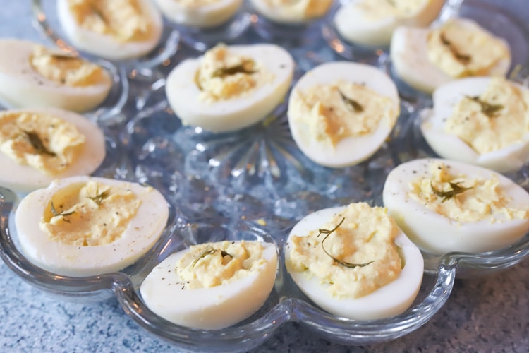 deviled eggs with dill on a serving tray