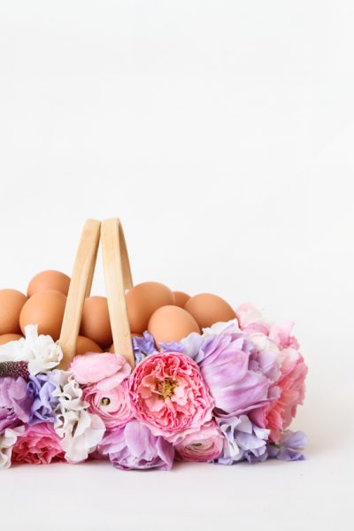 A floral Easter picnic basket filled with fresh brown eggs