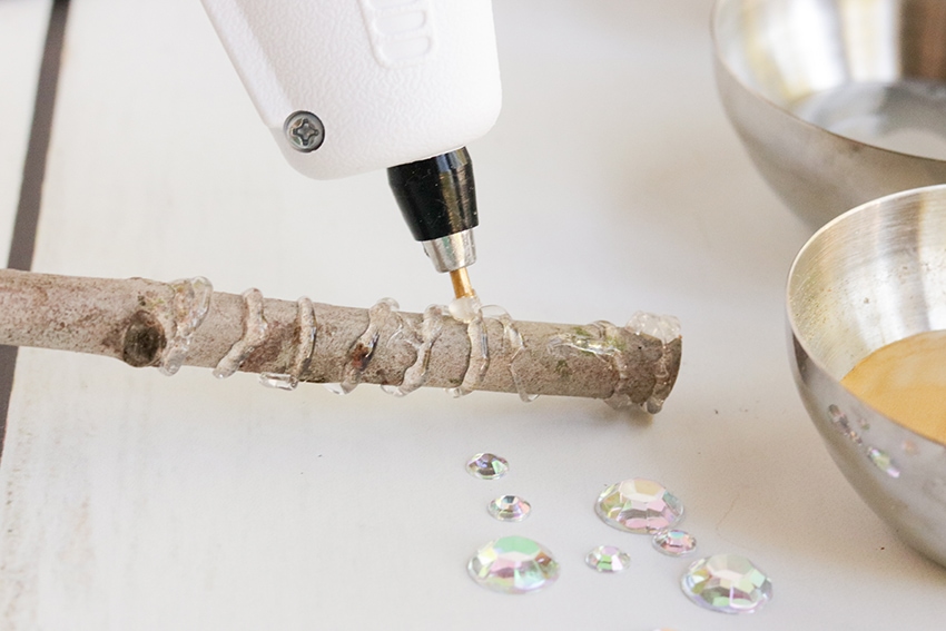 close up of hot glue gun being used to decorate a diy wand from harry potter