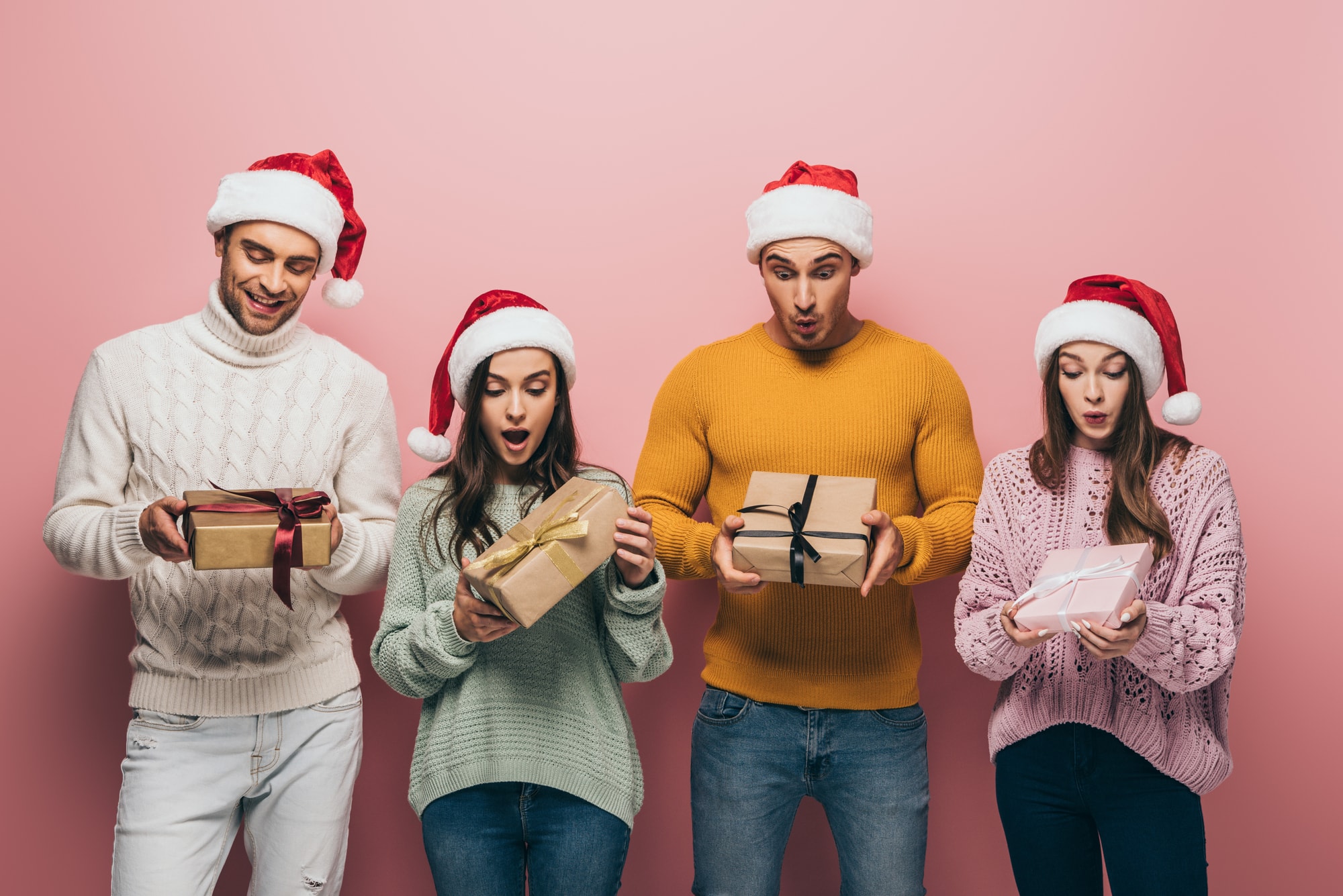 people excitedly holding Christmas white elephant gifts for exchange
