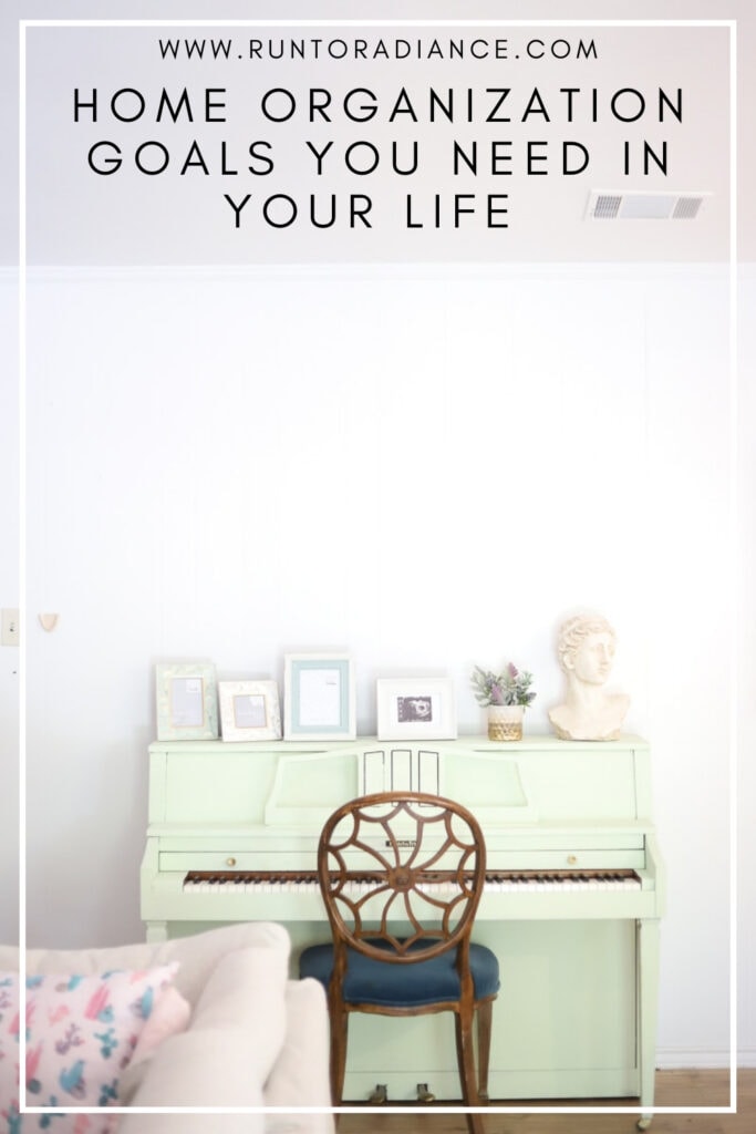 white background with a painted green piano, picture frames and brown chair