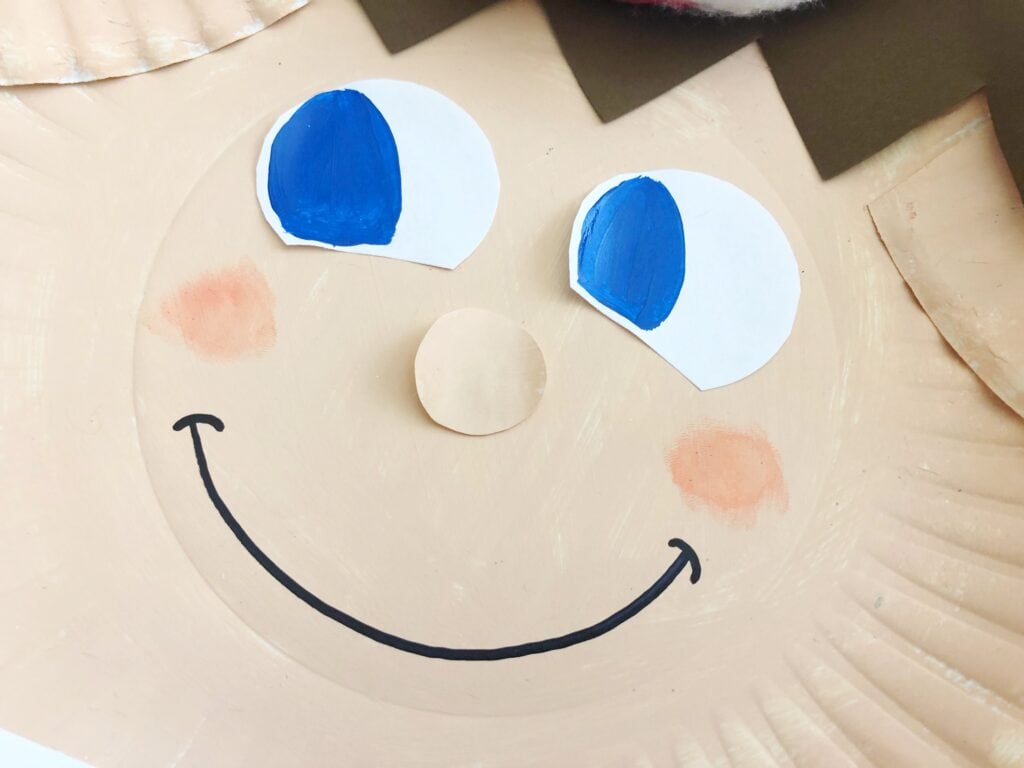 Blue-eyed elf on the shelf made up of paper plates.
