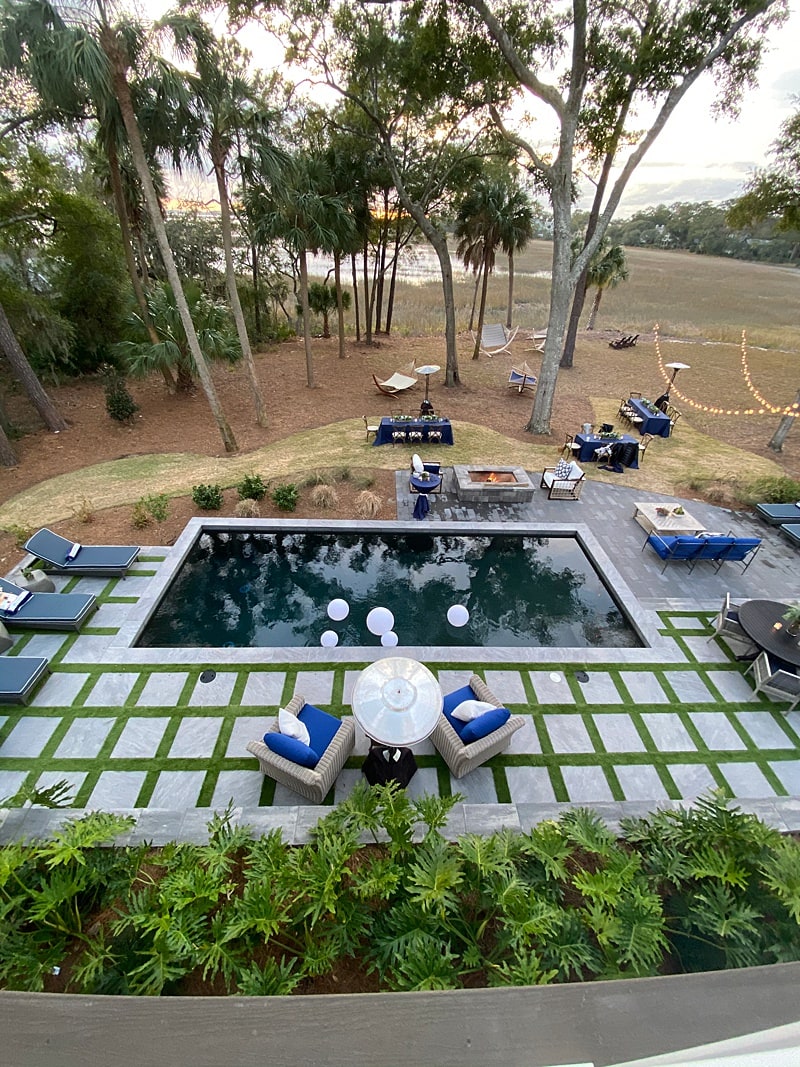 Overhead shot of swimming pool with pavers and turf, with ocean in background