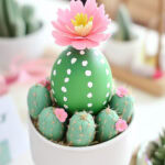 a big easter egg painted to look like a cactus in a planter
