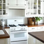 off white cabinets next to a white stove