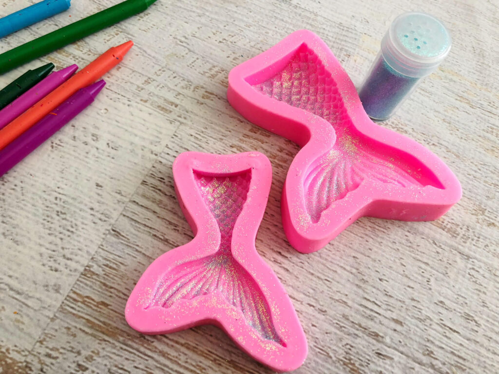 Glitter sprinkled in the bottom of a mermaid tail silicone mold