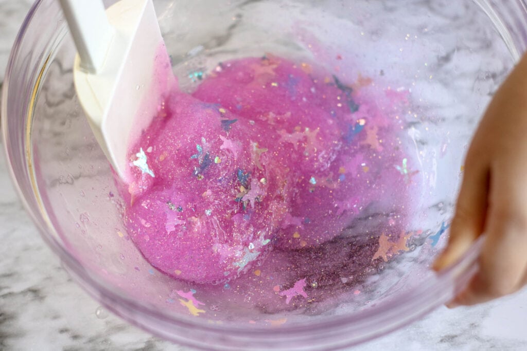 Add contact lens solution slowly and mixing in increments to the glue mixture to make DIY unicorn slime.