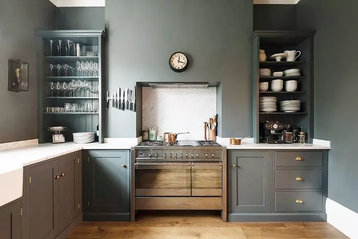 Deep, muted green kitchen cabinets with open shelving have a classic, rustic look in a monochromatic kitchen. Kitchen cabinet paint color: Vintage Vogue by Benjamin Moore.