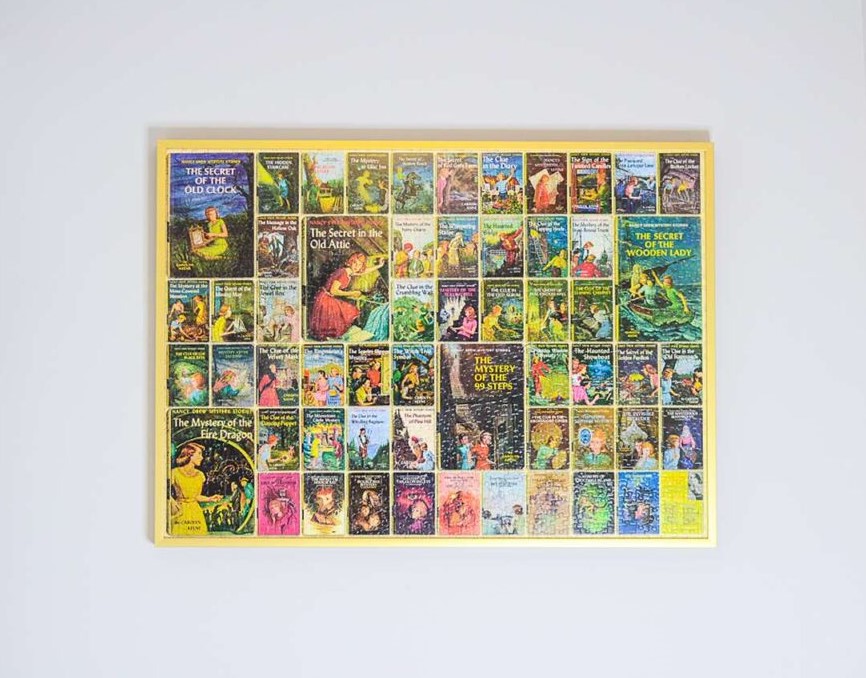 Multicolored puzzle in a yellow frame hanging on a white wall. 
