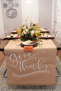 Thanksgiving table set with butcher paper with the words Give Thanks written on it.