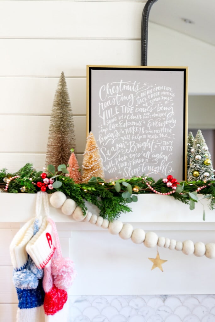 Using signs, wooden beads, bottle brushes as part of Christmas mantel decor