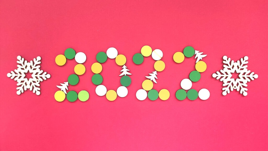 Multicolored numbers 2022 from kids wooden mosaic isolated on white background. Happy New Year concept with numbers, fir trees and Snowflakes.