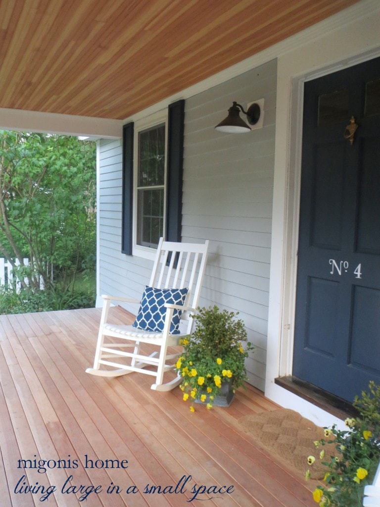front porch with shutters, a rocking chair, and potted plants