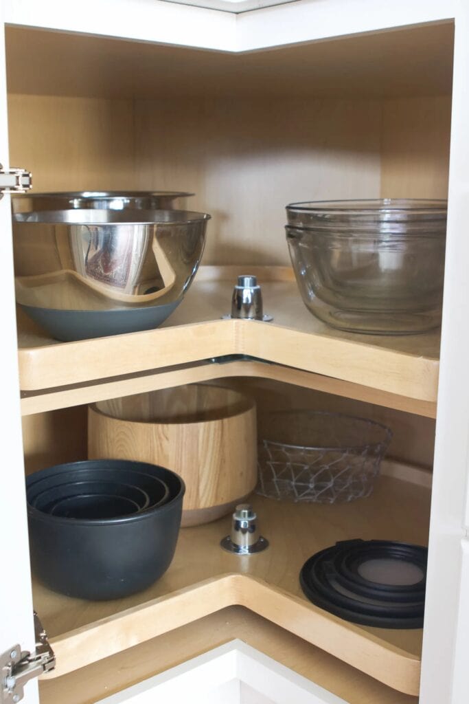 lazy susan style cabinet with stacked mixing bowls on the shelves
