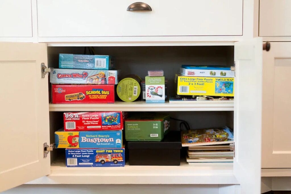 board games stored in the shelves of a media cabinet