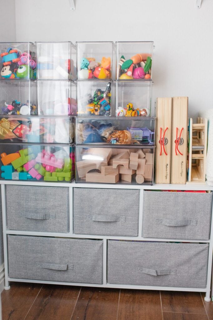 stacked clear bins with blocks and other colorful toys inside