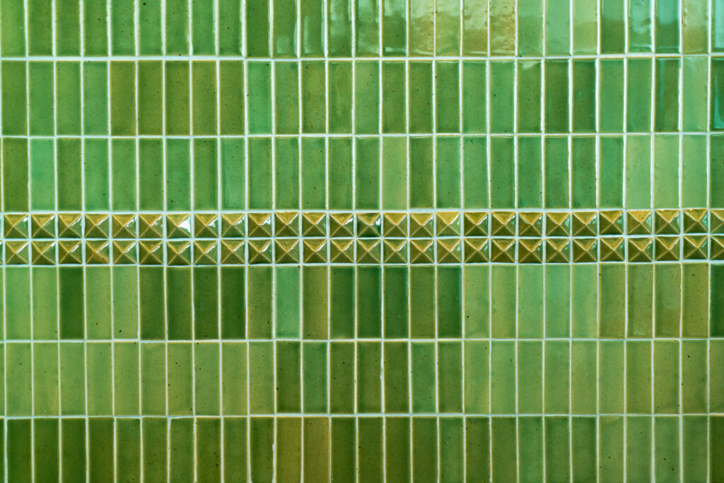 Small green subway tiles in vertical pattern.