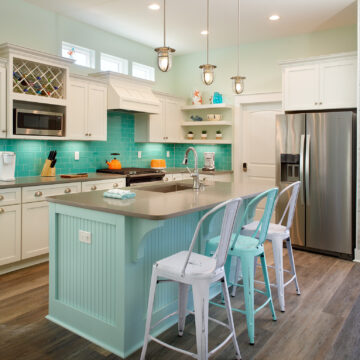 two-tone blue and white kitchen cabinets with aqua backsplash