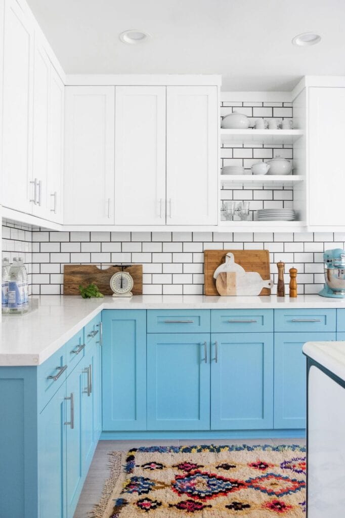 light blue kitchen cabinets against white subway tile and upper cabinets