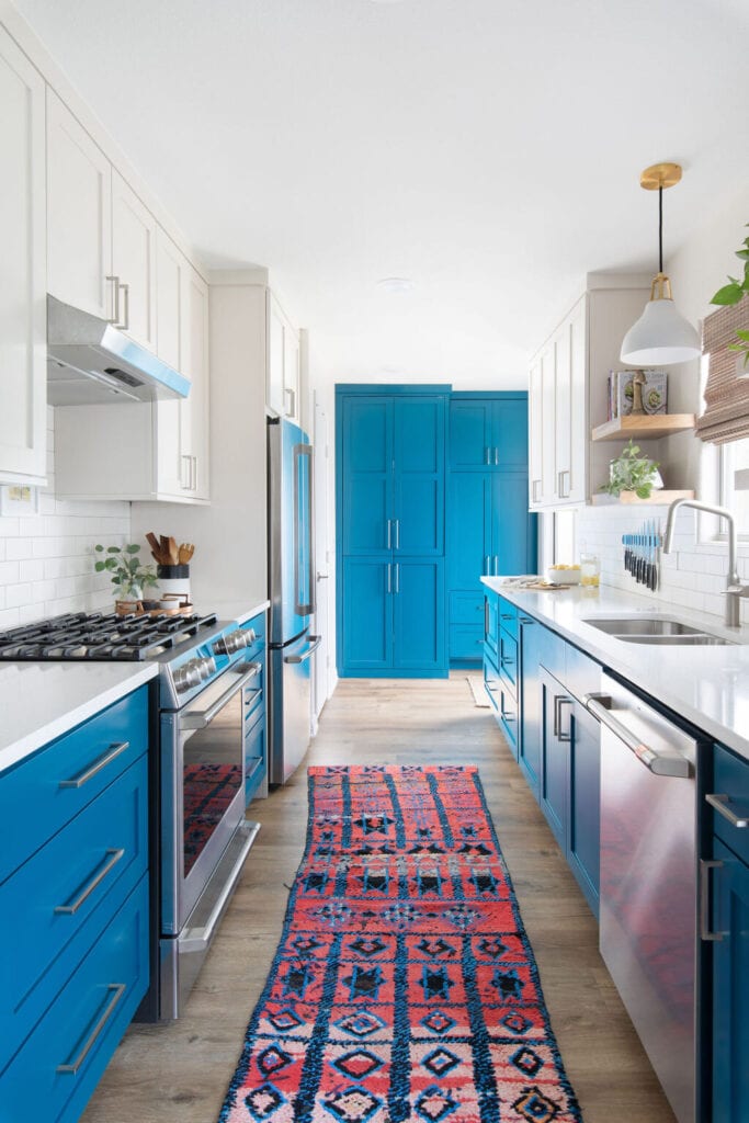 two-tone blue and white kitchen cabinets with bohemian style runner rug