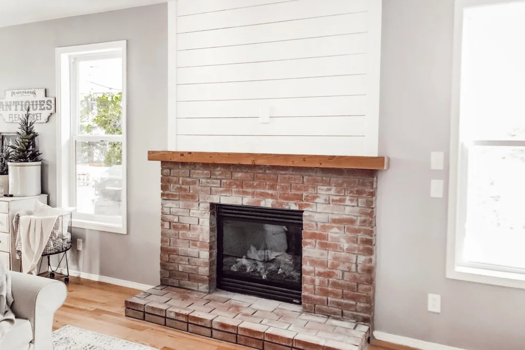 Shiplap wall with painted brick fireplace surround