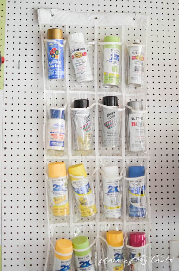 garage organization tip of using a plastic shoe holder to store spray paint cans