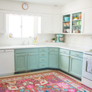 seafoam green painted lower cabinets against a large bright area rug