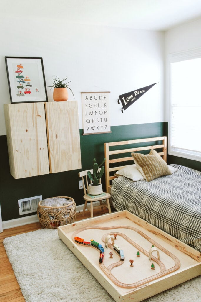 two toned bedroom walls with light wood furniture and toys