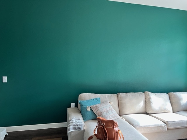 Green accent wall in living room.