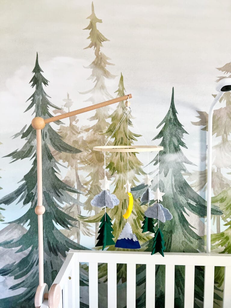 tree mural behind a wood and felt crib mobile